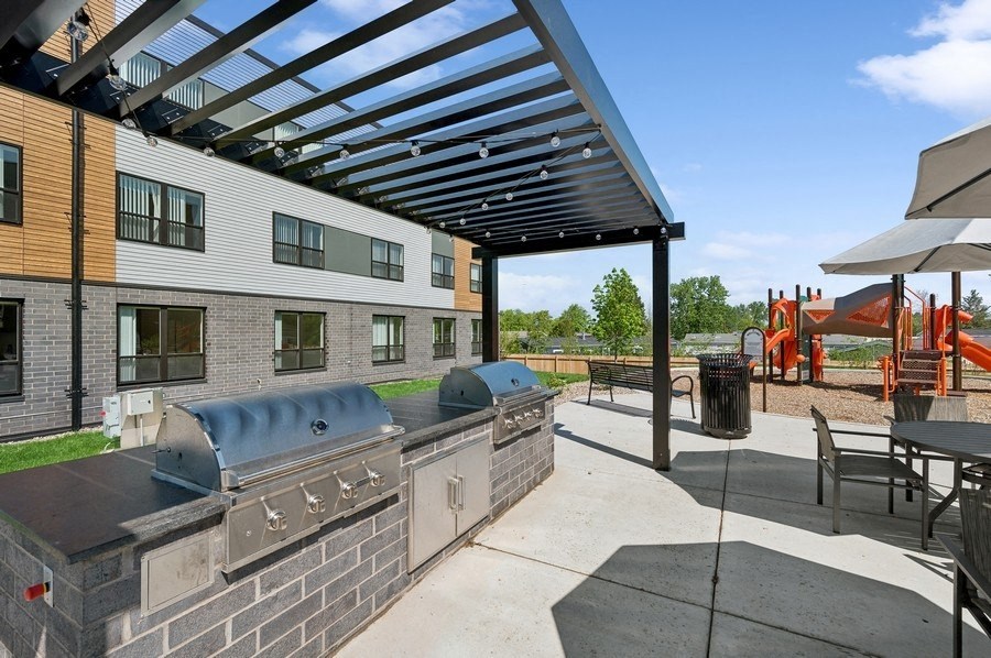 A patio area with a grill and seating area.