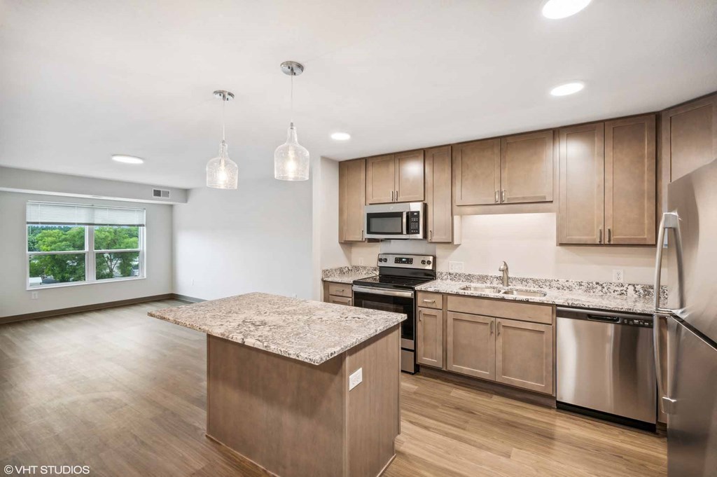 A kitchen with wooden cabinets and a granite countertop.