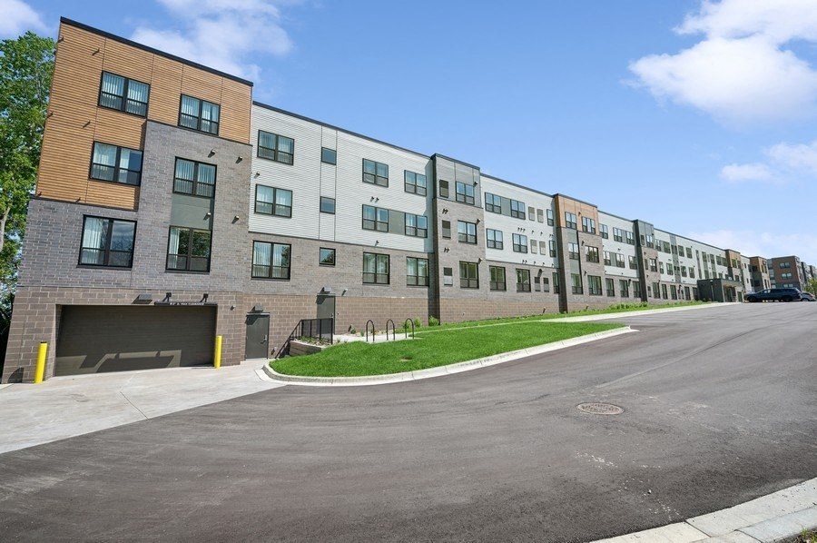 A long building with a parking lot in front.
