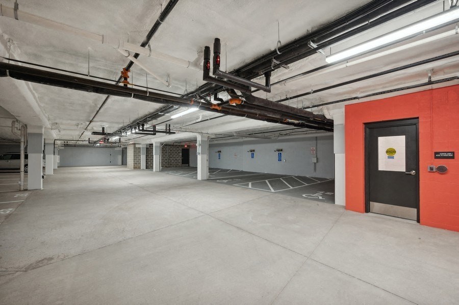 A parking garage with a red door on the right side.