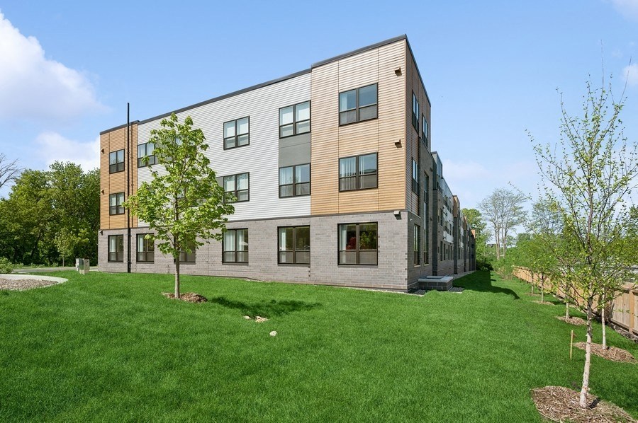 A modern building with a green lawn in front.