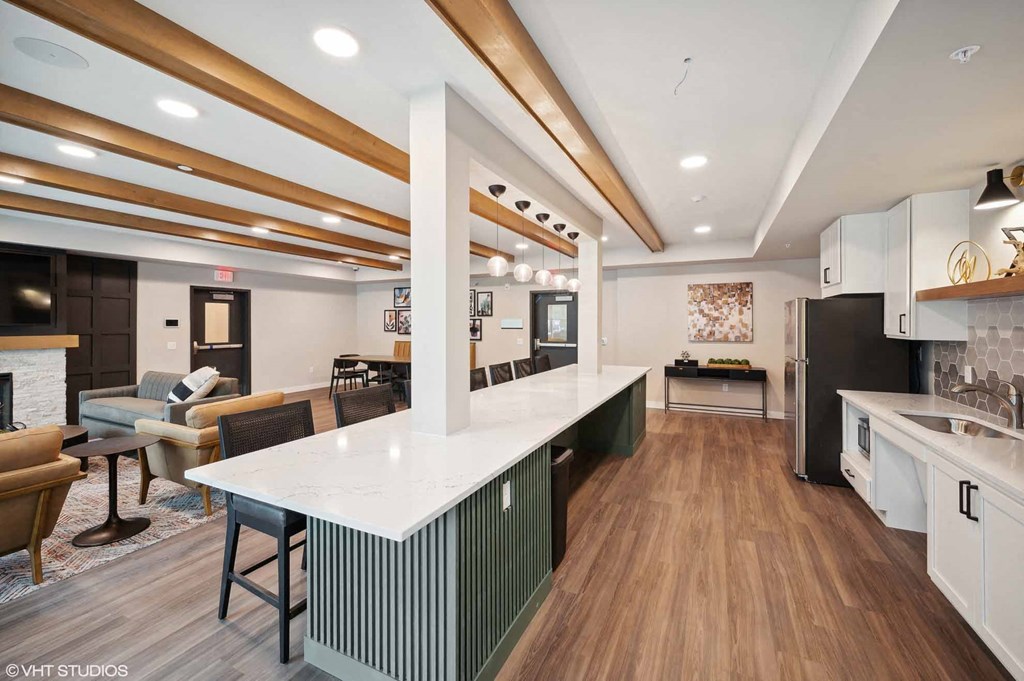 A modern kitchen with a white countertop and wooden flooring.