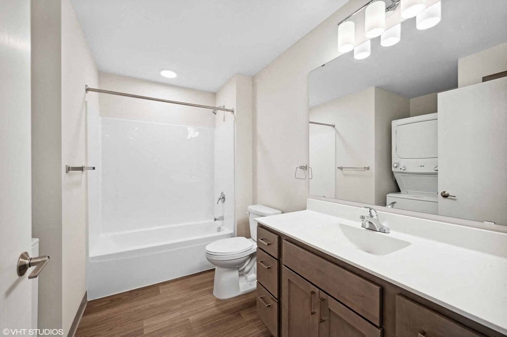 A white toilet sits in a bathroom next to a sink.