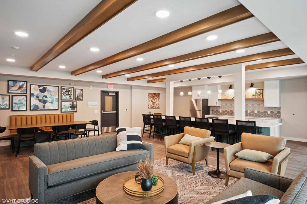 A living room with a grey couch, wooden coffee table and a large painting on the wall.