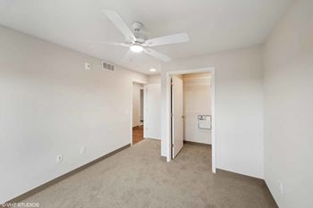 a living room with white walls and a ceiling fan