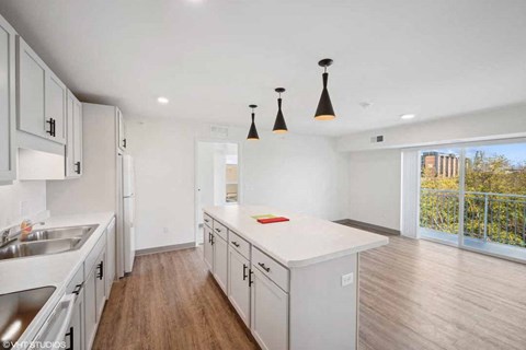A kitchen with white cabinets and a wooden floor.