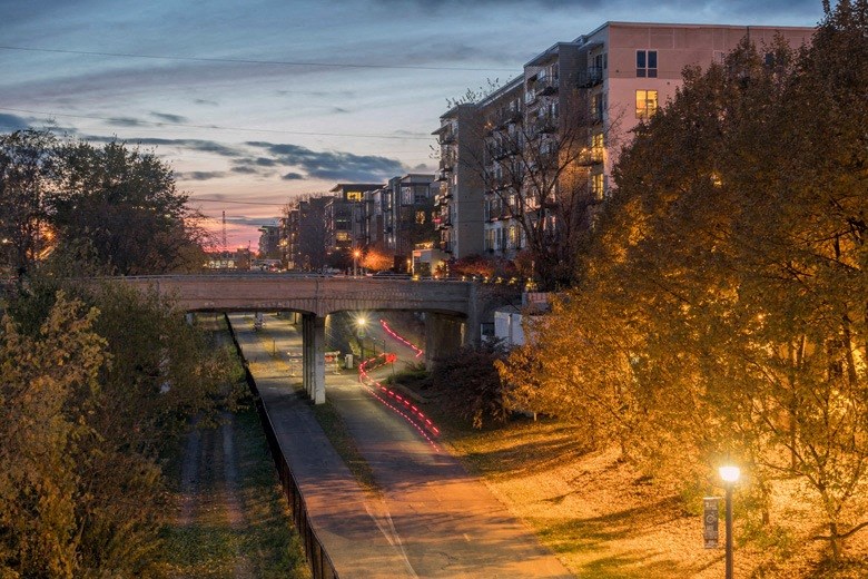 A bridge over a road with trees on the side.
