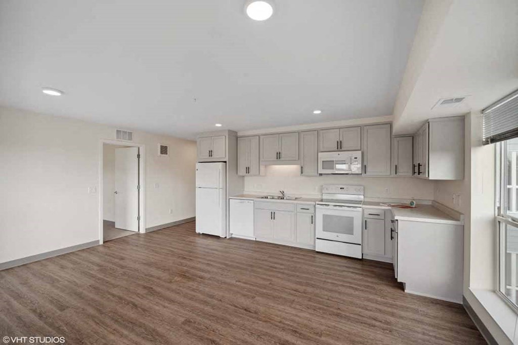 an empty room with white cabinets and appliances in it