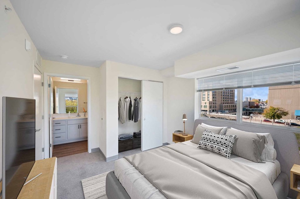 A bedroom with a large bed and a view of the city.