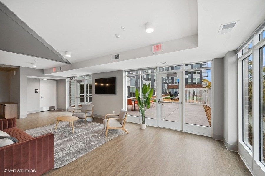 A modern living room with a flat screen TV and sliding glass doors.
