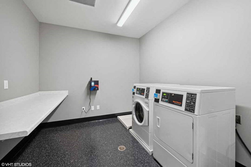 a white laundry room with a washer and a dryer