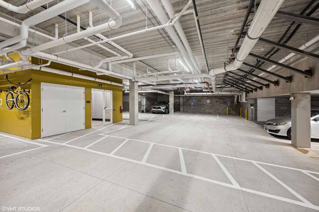 A spacious garage with a yellow wall and white doors.