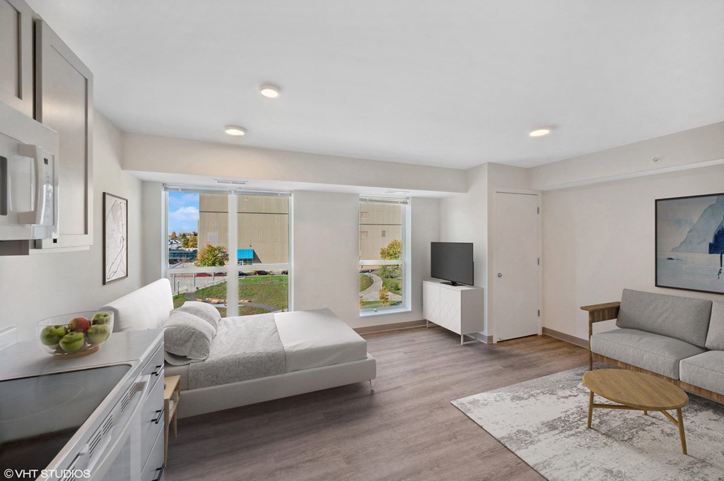 a living room with a couch and a bed and a tv