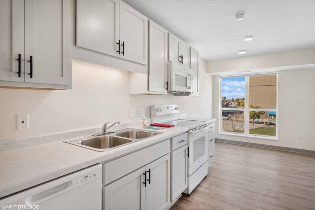 A kitchen with white cabinets and appliances.