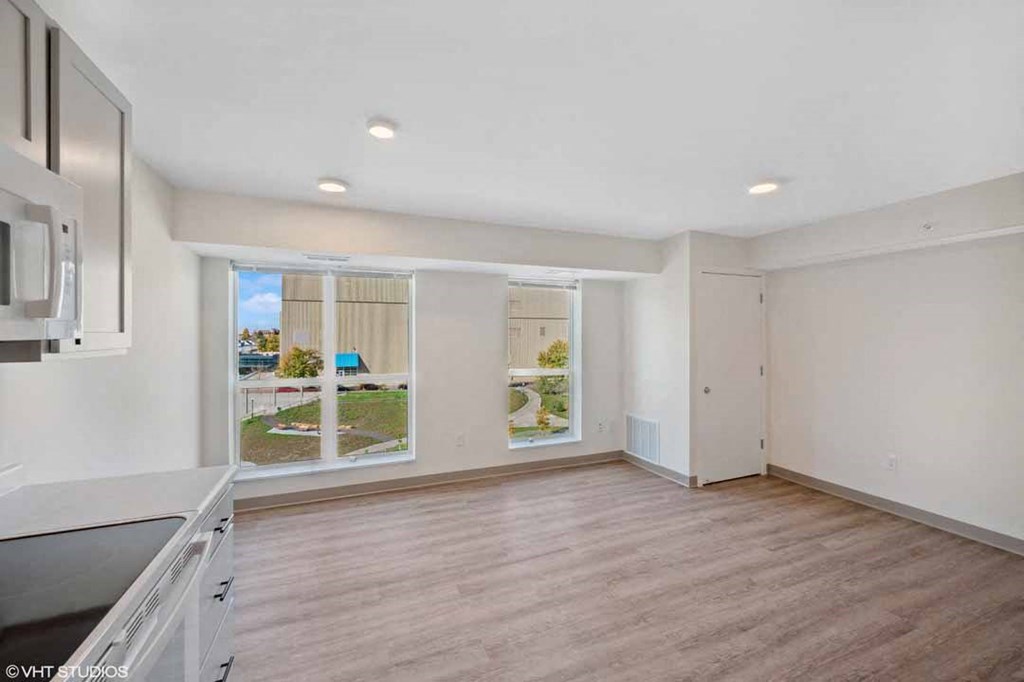 an empty kitchen and living room with a large window