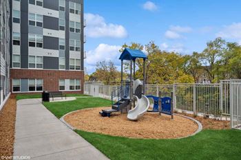 a playground with a slide in front of an apartment building