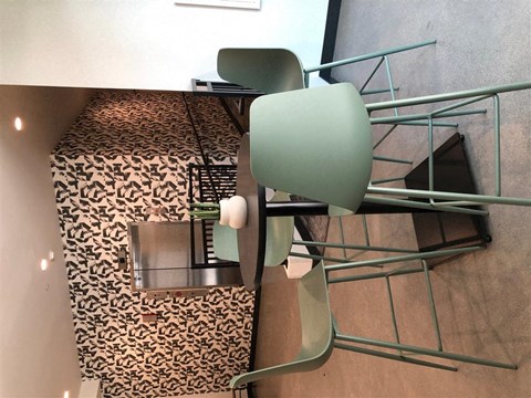 a dining room table with a green chair and a leopard print
