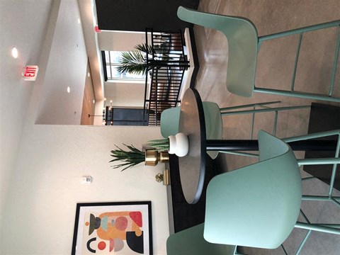 a view from the top of a stairwell of a building with green furniture