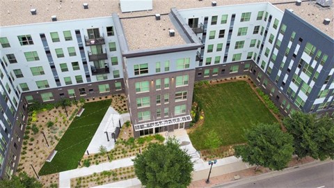 an aerial view of an apartment building with a green lawn