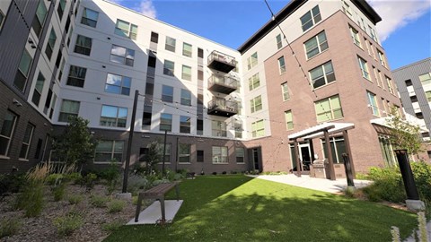 the courtyard of an apartment building with a green lawn