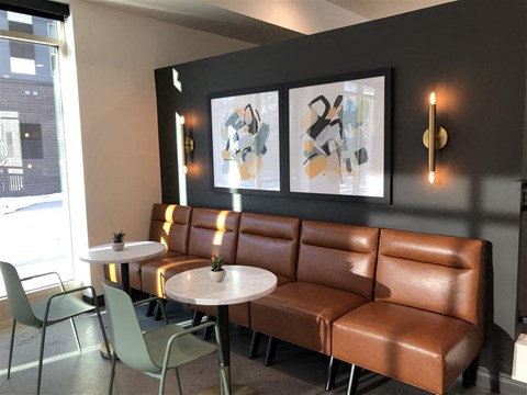 a seating area of a restaurant with leather couches and tables