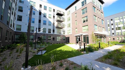 a courtyard in front of a building with a green lawn