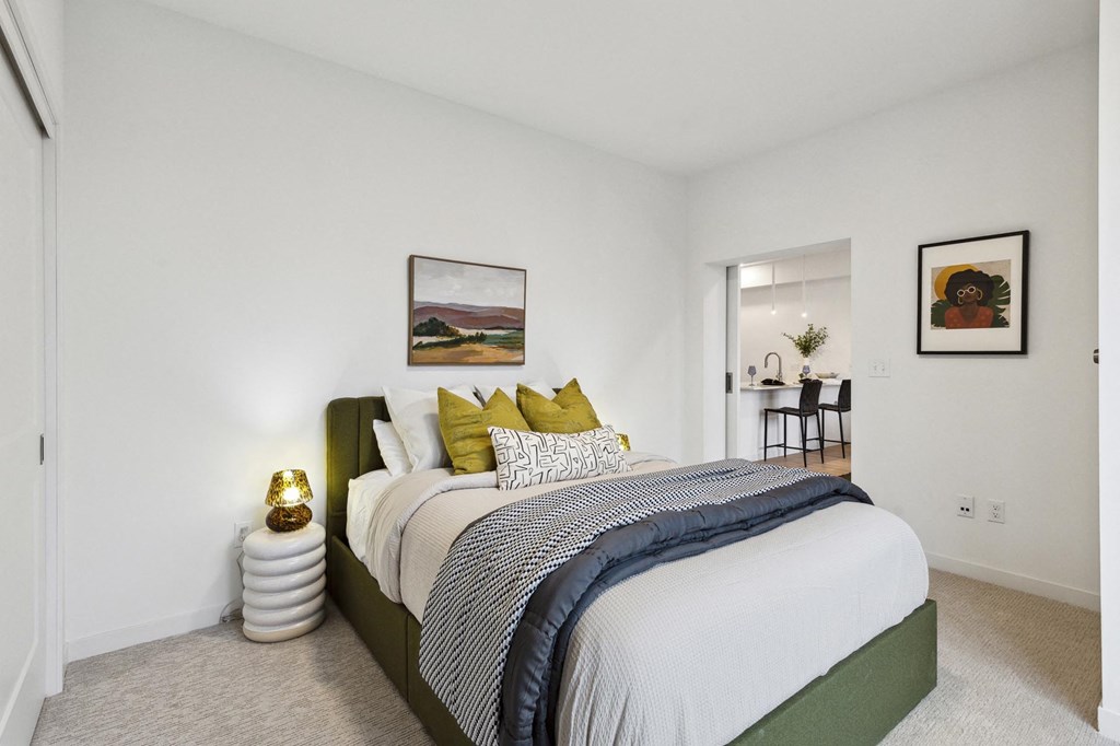 A bedroom with a large bed and a painting on the wall.