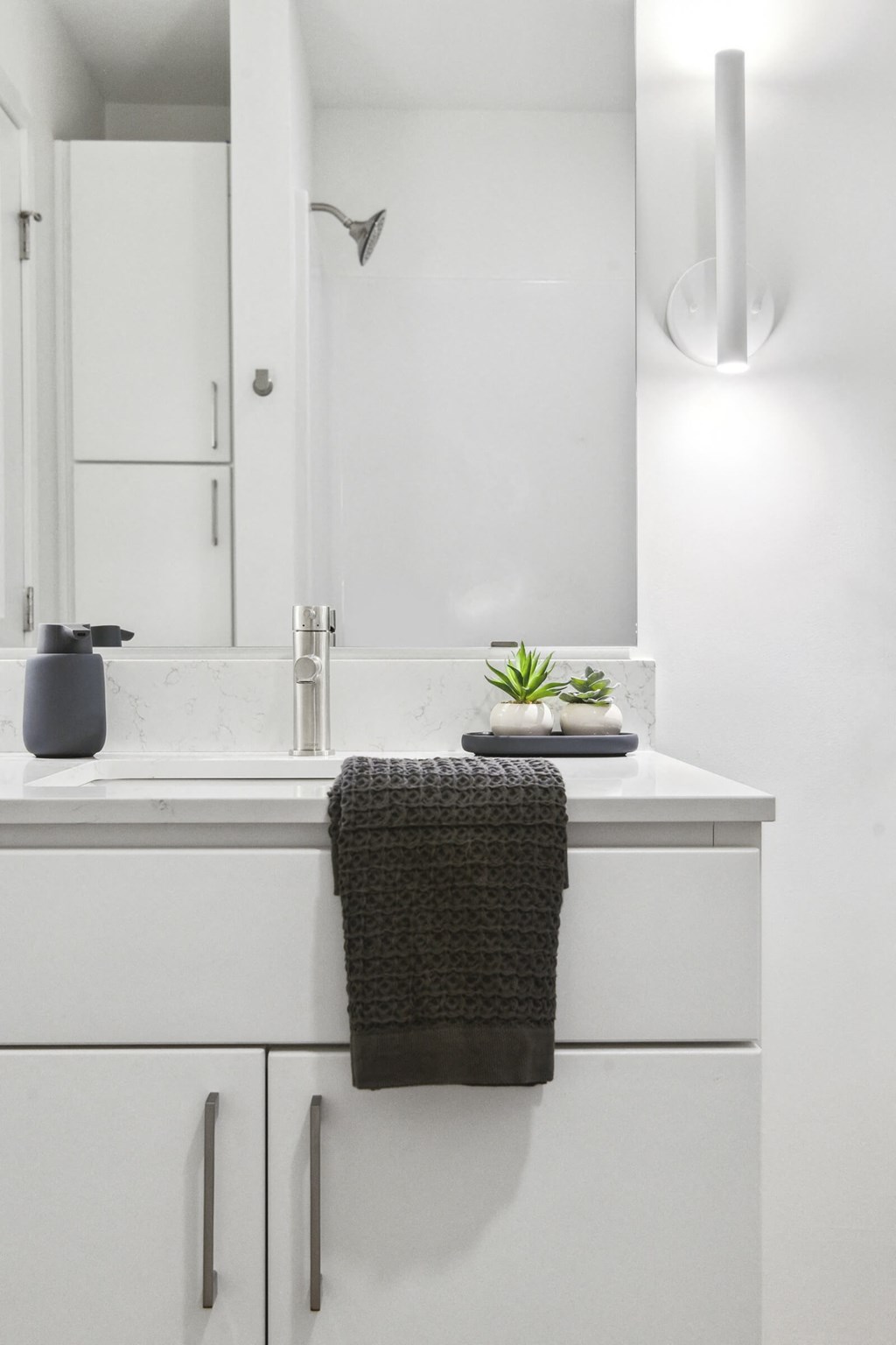 A bathroom with a white counter and a grey towel.