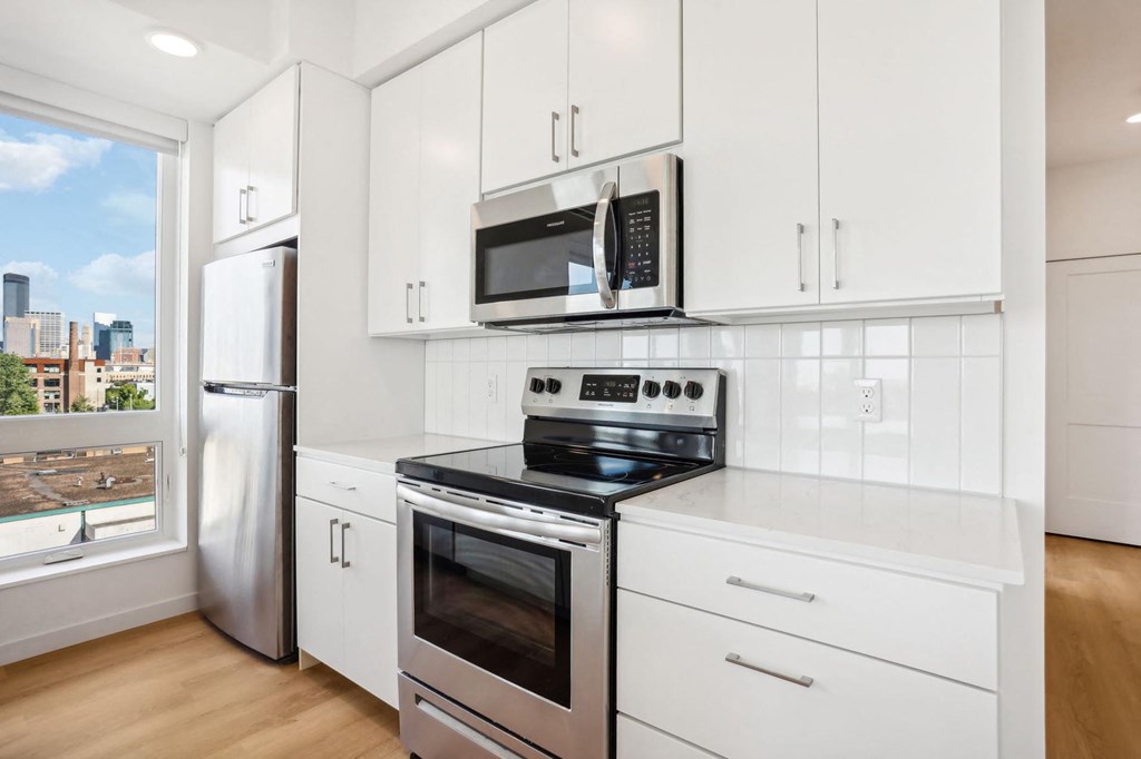 A kitchen with white cabinets and stainless steel appliances.