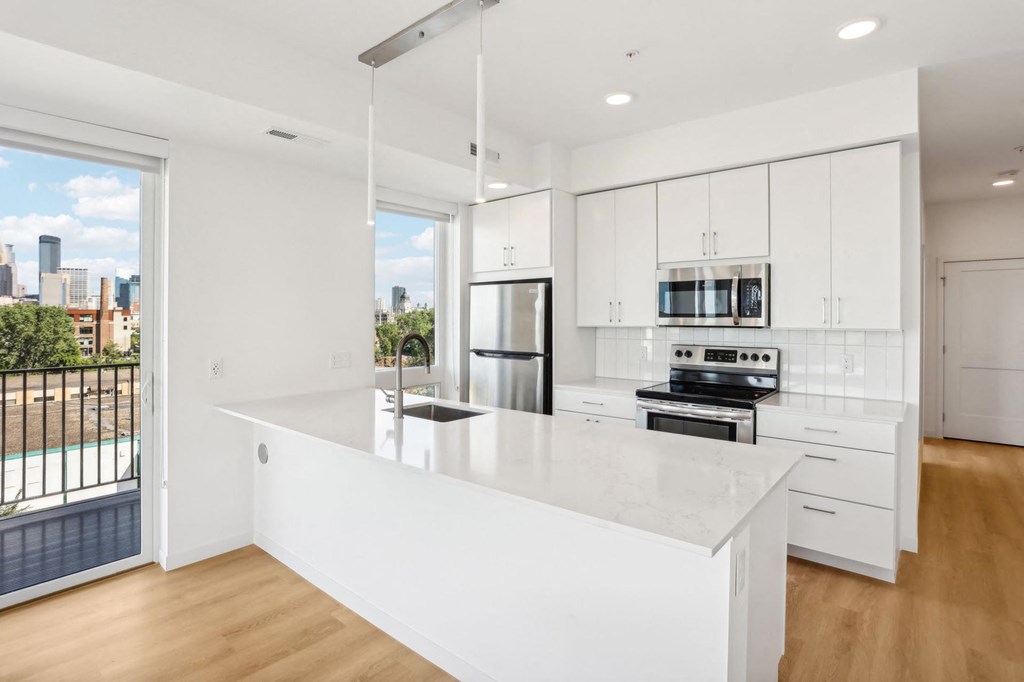 A modern kitchen with white cabinets and appliances.