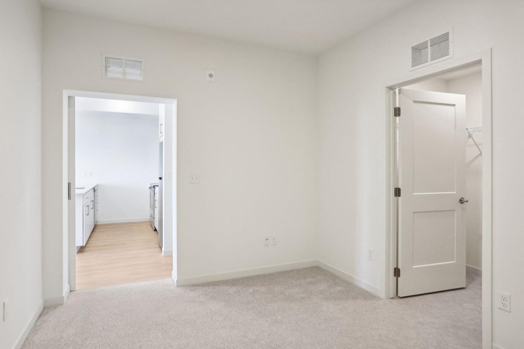 A white room with a carpeted floor and two doors.
