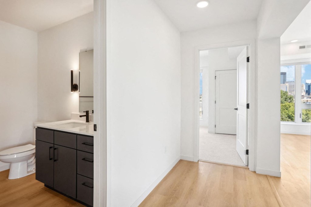 A bathroom with a toilet, sink, and cabinet.