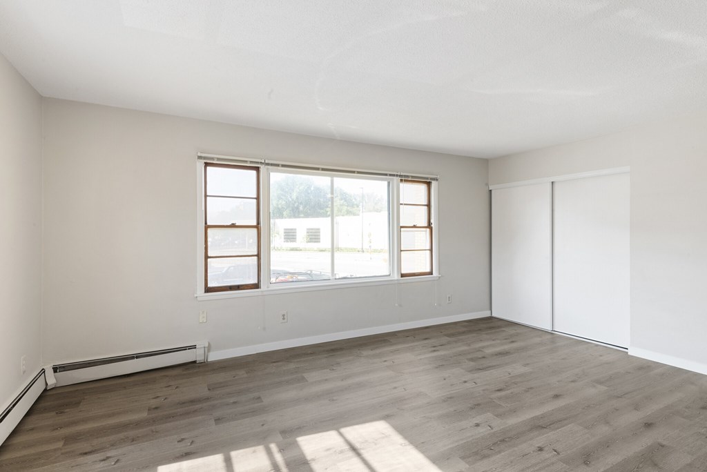 A room with a window and a wooden floor.