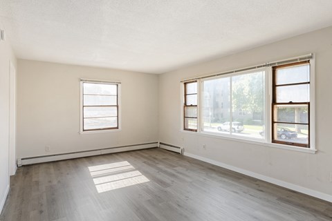 A room with two windows and wooden flooring.