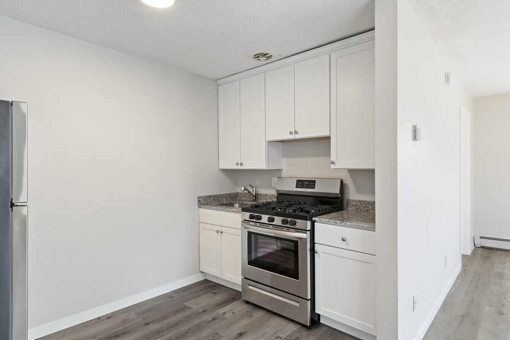 A kitchen with white cabinets and stainless steel appliances.