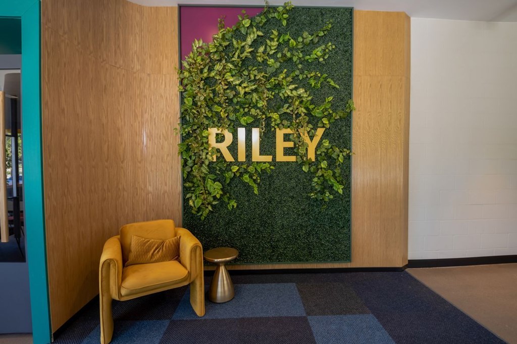 A green plant wall with the word RILEY on it.