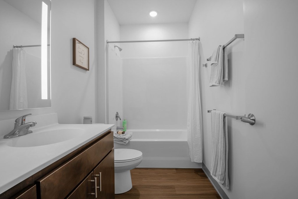A white bathroom with a toilet, sink, and bathtub.
