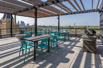a roof deck with tables and chairs and a view of the city