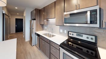 a modern kitchen with stainless steel appliances and white counter tops