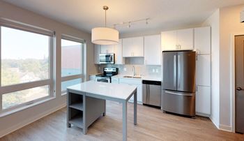 a modern kitchen with stainless steel appliances and a table