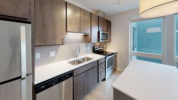 a modern kitchen with stainless steel appliances and white counter tops