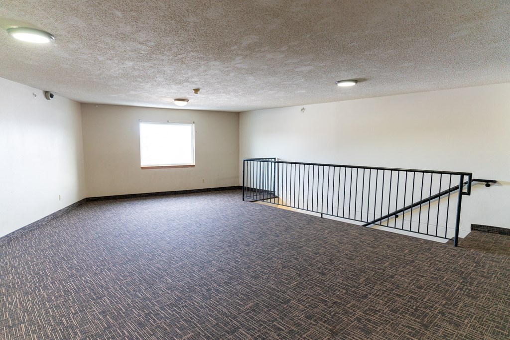 A room with a carpeted floor and a window.
