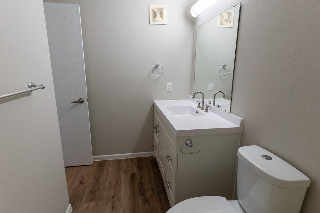 A white toilet sits next to a sink in a small bathroom.