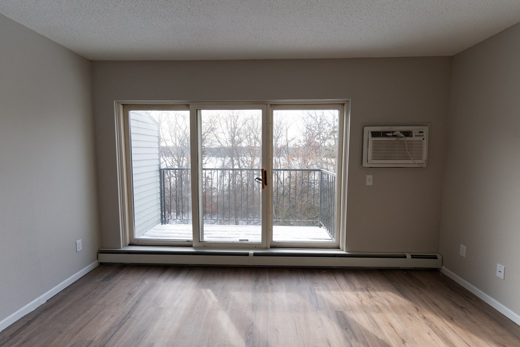 A room with a sliding glass door leading to a snowy outdoor area.