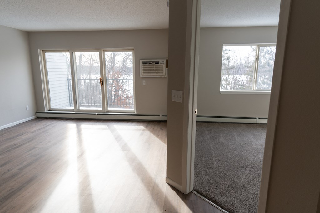 A room with a carpeted floor and a sliding glass door.