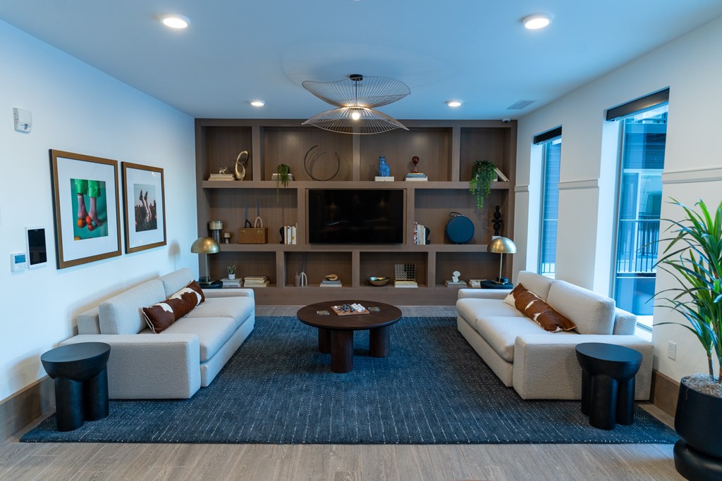A modern living room with a large sofa set, a coffee table, and a TV.