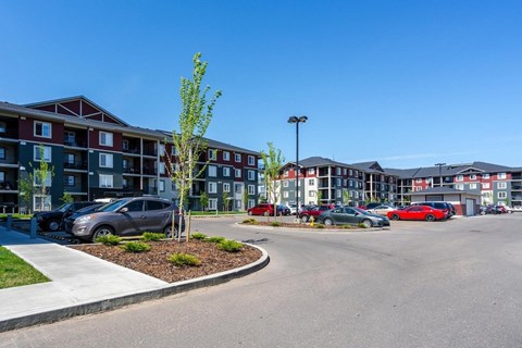 A parking lot with cars and apartment buildings in the background.