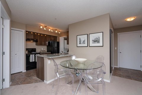 A kitchen with a glass table and chairs.