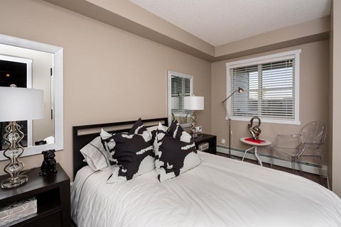 A bedroom with a white bed and a black and white pillow.
