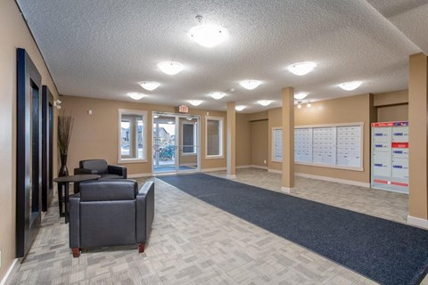 A waiting room with a carpeted floor and a large window.